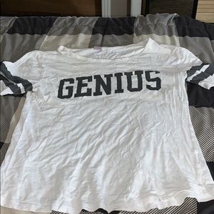 White tee with black stripes and says “genius “